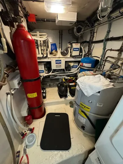 Moonshine Yacht Photos Pics Engine room of a 1985 Hatteras Enclosed Bridge yacht, featuring equipment and piping.