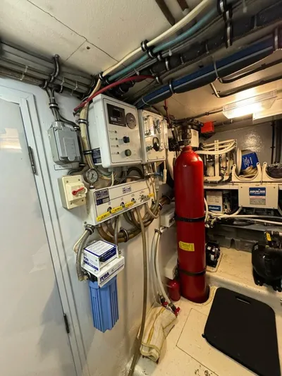 Moonshine Yacht Photos Pics Engine room of 1985 Hatteras Enclosed Bridge yacht with control panels and fire extinguisher.