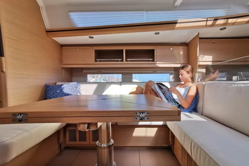  Yacht Photos Pics Woman reading in the cozy interior of a 2020 Dufour 56 Exclusive yacht.