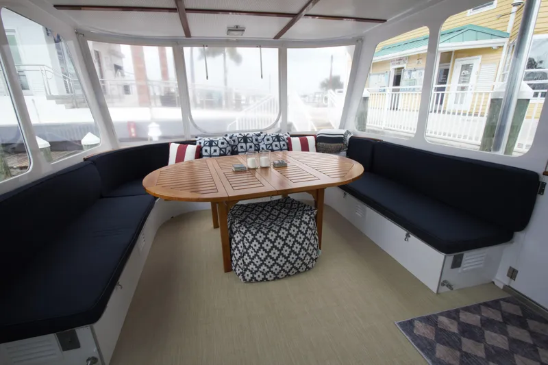  Yacht Photos Pics 1963 Huckins Linwood yacht interior with cozy seating and wooden table.
