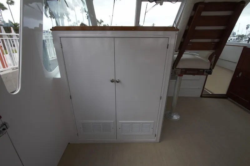  Yacht Photos Pics 1963 Huckins Linwood boat interior with white cabinet and wooden chair.