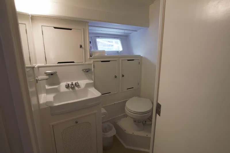  Yacht Photos Pics 1963 Huckins Linwood yacht bathroom with sink, toilet, and storage cabinets.