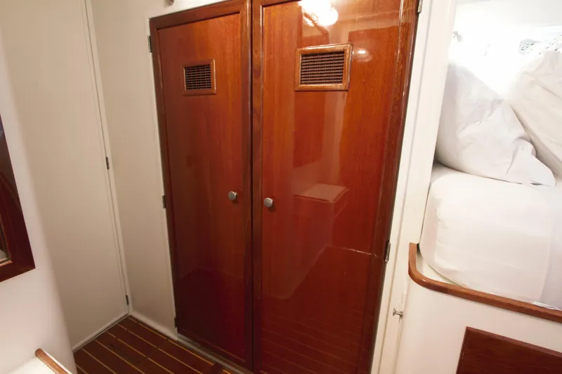  Yacht Photos Pics 1963 Huckins Linwood yacht interior with wooden cabinets and cozy bedding.
