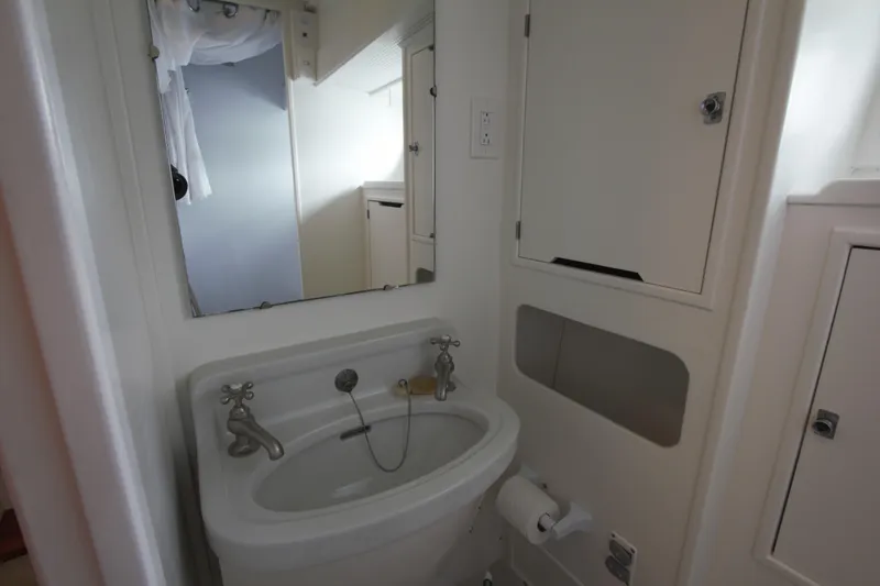  Yacht Photos Pics Compact bathroom in a 1963 Huckins Linwood boat with sink and mirror.