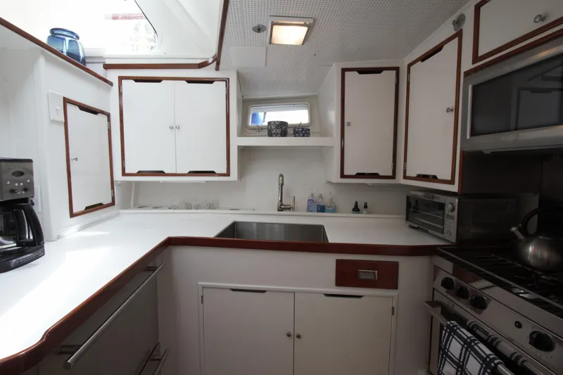  Yacht Photos Pics 1963 Huckins Linwood yacht kitchen with white cabinets and modern appliances.