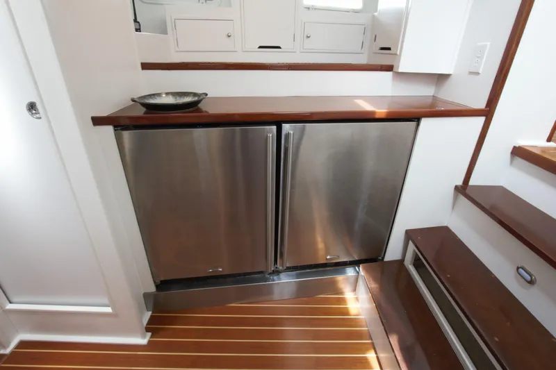  Yacht Photos Pics Stainless steel fridge in 1963 Huckins Linwood yacht interior with wooden flooring.