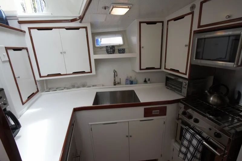  Yacht Photos Pics 1963 Huckins Linwood yacht kitchen with modern appliances and white cabinetry.