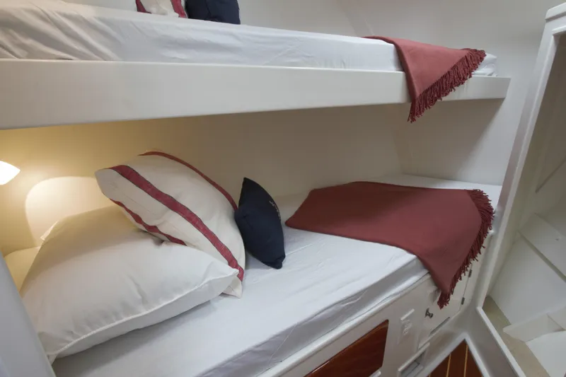  Yacht Photos Pics Bunk beds in a 1963 Huckins Linwood yacht cabin with cozy bedding and soft lighting.
