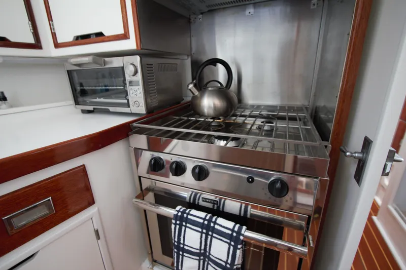  Yacht Photos Pics Compact kitchen in a 1963 Huckins Linwood boat with stove, kettle, and toaster oven.