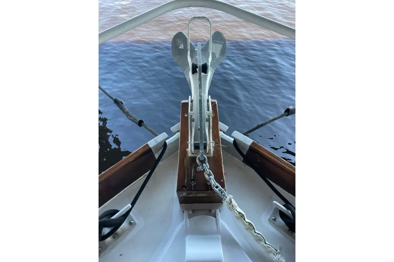  Yacht Photos Pics Bow view of 1963 Huckins Linwood boat with anchor and chain over water.