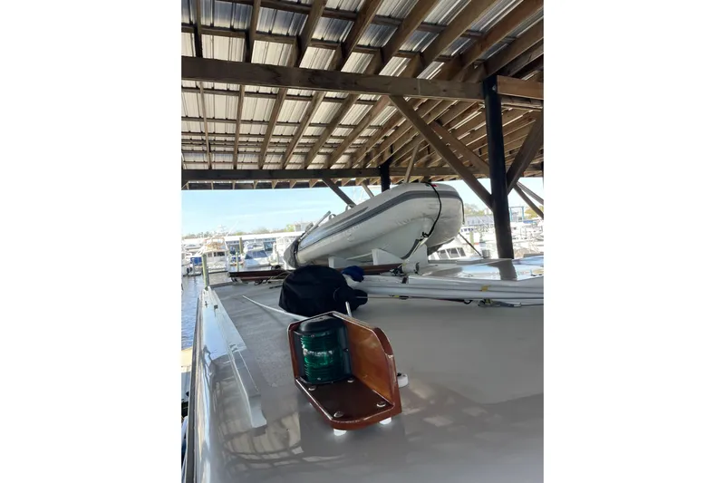  Yacht Photos Pics 1963 Huckins Linwood yacht under covered dock with inflatable boat on deck.
