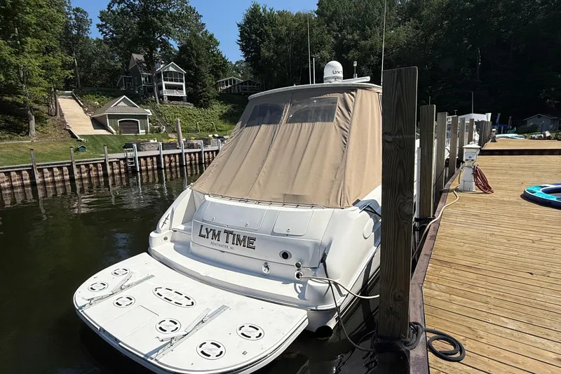  Yacht Photos Pics 1998 Sea Ray 540 Sundancer docked at a serene lakeside marina.