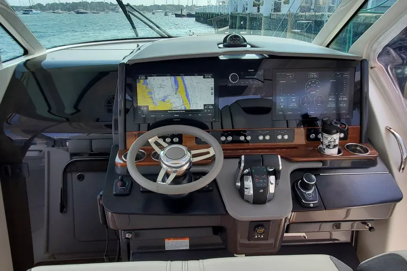 Pouge Life Yacht Photos Pics 2021 Tiara Sport 38 LS helm with advanced navigation and control systems, docked by the water.