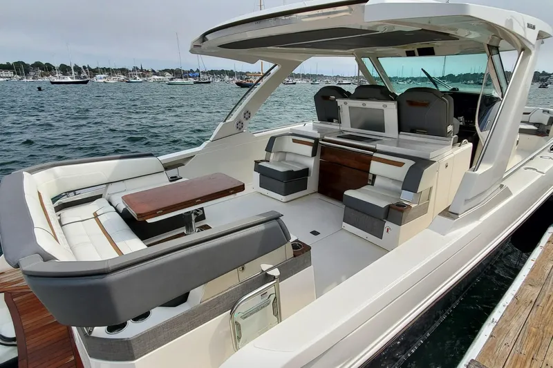 Pouge Life Yacht Photos Pics 2021 Tiara Sport 38 LS luxury boat interior with seating and table, docked by the water.