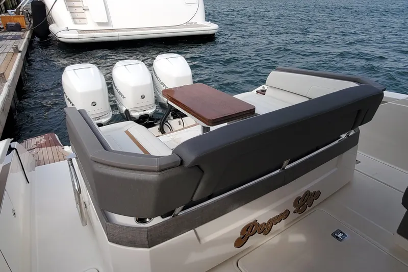 Pouge Life Yacht Photos Pics 2021 Tiara Sport 38 LS boat with triple Mercury outboard engines, docked by the water.