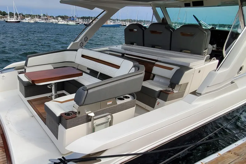 Pouge Life Yacht Photos Pics 2021 Tiara Sport 38 LS luxury boat interior with seating and table, docked in a marina.