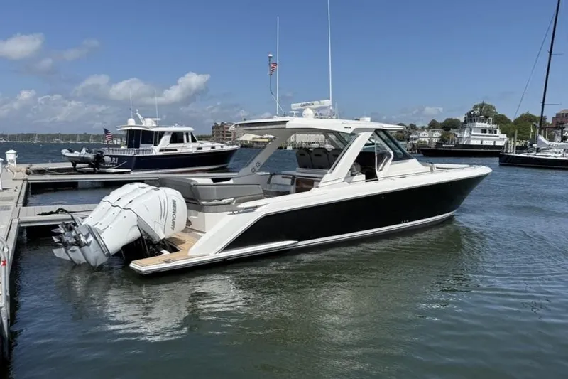 Pouge Life Yacht Photos Pics 2021 Tiara Sport 38 LS boat docked in a marina under a clear blue sky.