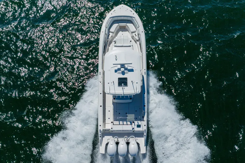 Blue Skies Yacht Photos Pics 2022 Pursuit S 378 Sport boat cruising on open water, aerial view.