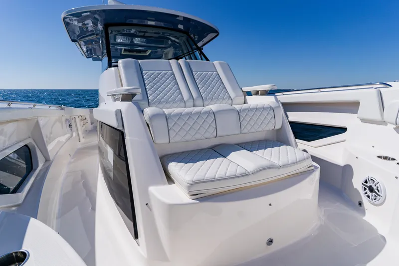 Blue Skies Yacht Photos Pics 2022 Pursuit S 378 Sport boat with luxurious seating and ocean backdrop.