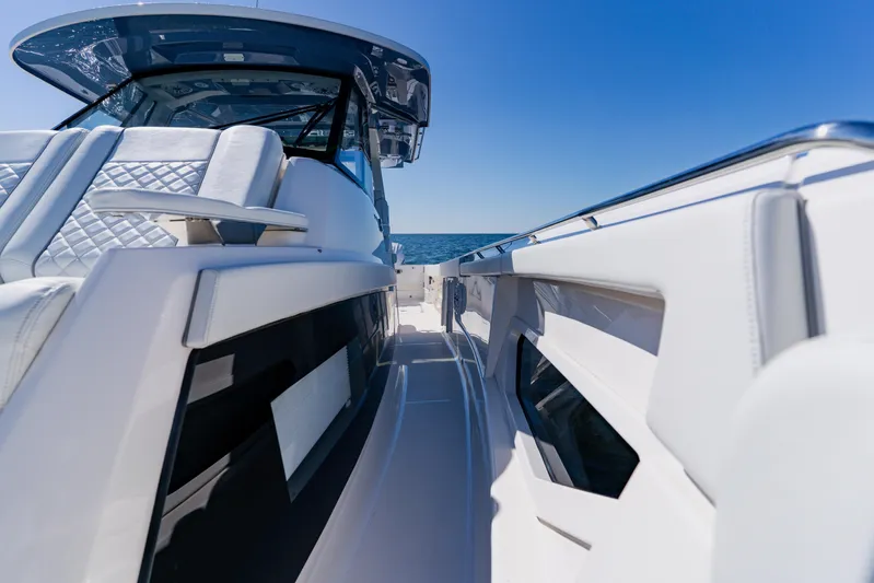 Blue Skies Yacht Photos Pics 2022 Pursuit S 378 Sport boat, sleek design, luxury seating, ocean backdrop.