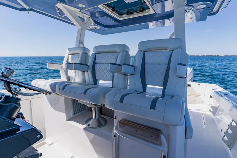 Blue Skies Yacht Photos Pics Luxury seating on 2022 Pursuit S 378 Sport boat, ocean backdrop.