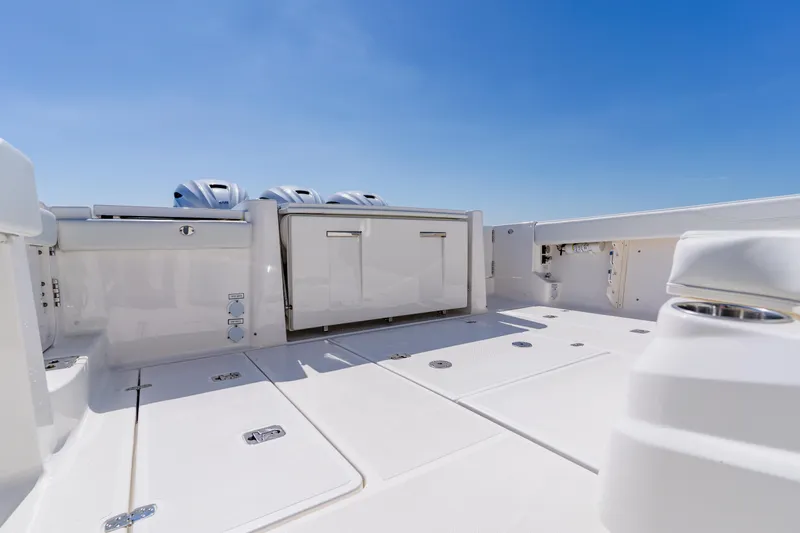 Blue Skies Yacht Photos Pics 2022 Pursuit S 378 Sport boat deck with storage and engines under clear sky.