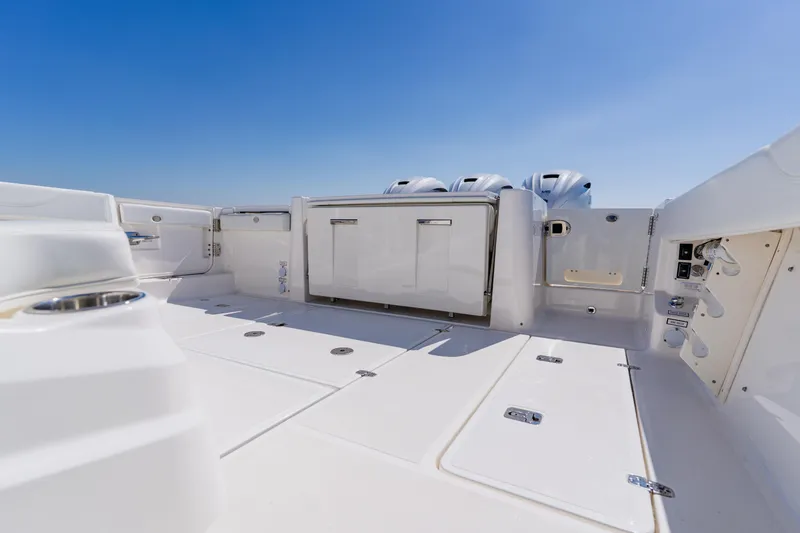 Blue Skies Yacht Photos Pics 2022 Pursuit S 378 Sport boat deck with storage and engine view.