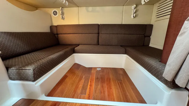  Yacht Photos Pics 2008 Boston Whaler 345 Conquest cabin interior with brown cushioned seating and wooden flooring.