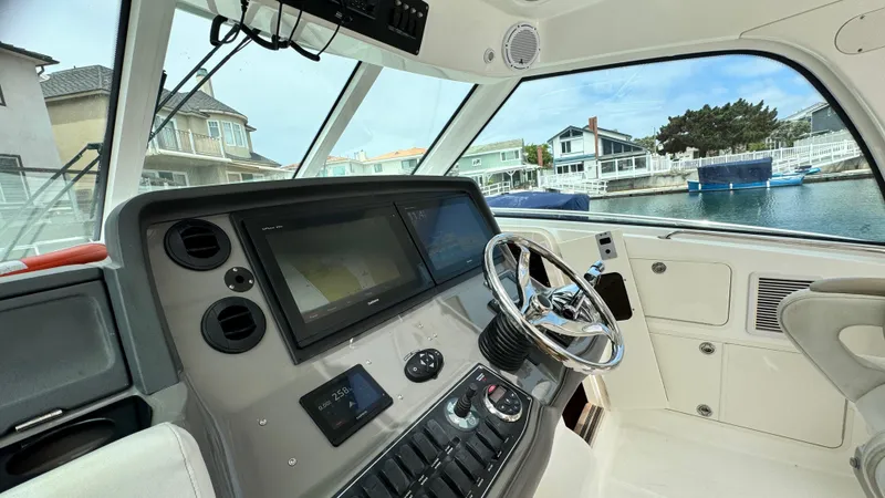  Yacht Photos Pics Helm of 2008 Boston Whaler 345 Conquest with modern navigation equipment, docked near waterfront homes.