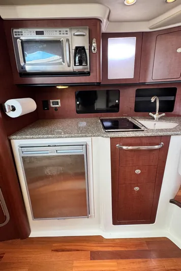  Yacht Photos Pics Kitchen area of a 2008 Boston Whaler 345 Conquest with microwave, sink, and fridge.