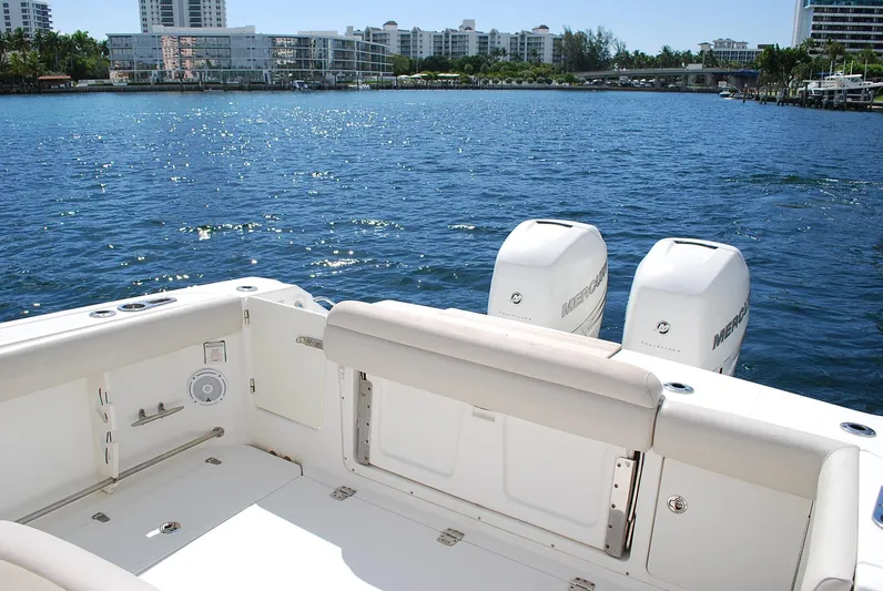  Yacht Photos Pics 2017 Boston Whaler 330 Outrage boat with twin Mercury engines on a sunny waterfront.