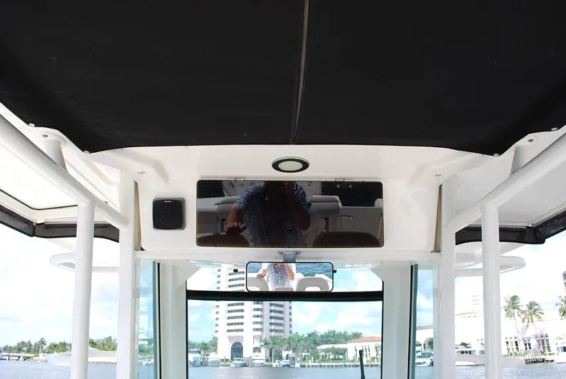  Yacht Photos Pics 2017 Boston Whaler 330 Outrage boat interior with black canopy and waterfront view.