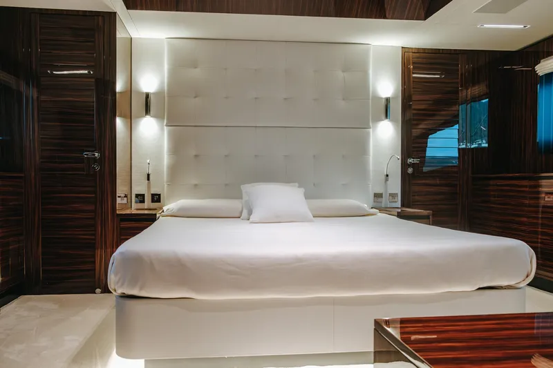  Yacht Photos Pics Luxurious bedroom interior on 2022 Riva 82' Diva yacht with elegant wood finishes.