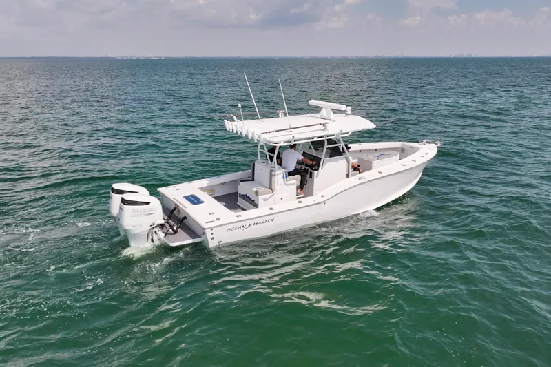  Yacht Photos Pics 1996 Ocean Master 31 Center Console boat cruising on open water.