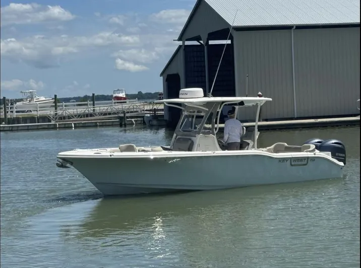  Yacht Photos Pics 2023 Key West 263 FS boat cruising near a dock under a clear sky.