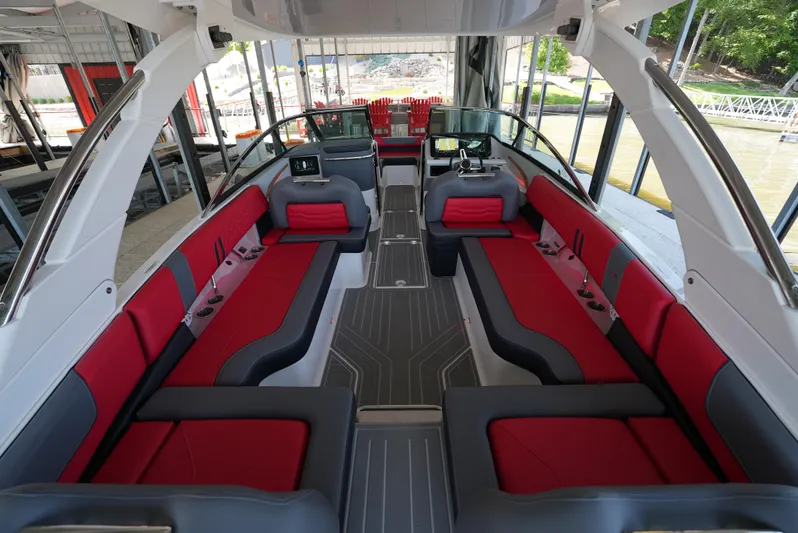  Yacht Photos Pics Luxurious 2025 Regal LS9 boat interior with red and gray seating, docked in a marina.