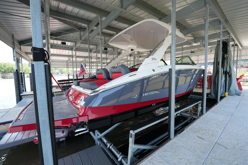  Yacht Photos Pics 2025 Regal LS9 boat docked in a covered marina, featuring sleek red and white design.
