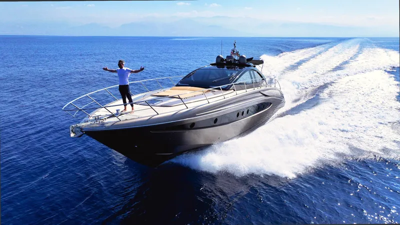 W Yacht Photos Pics Luxurious 2009 Riva 63 Vertigo yacht cruising on open sea with person on deck.