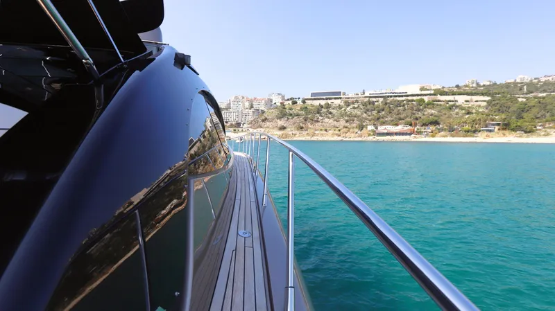 W Yacht Photos Pics 2009 Riva 63 Vertigo yacht cruising on clear blue waters near a scenic coastline.