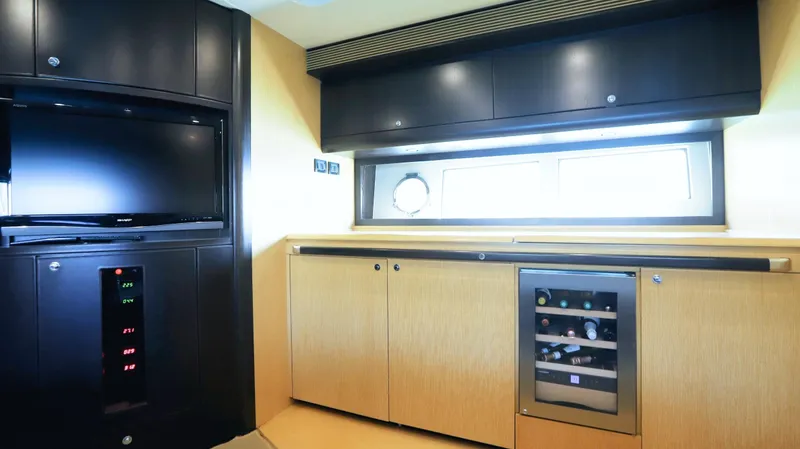 W Yacht Photos Pics Interior of 2009 Riva 63 Vertigo yacht with TV, cabinets, and wine cooler.