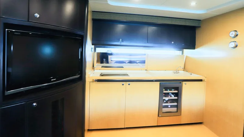 W Yacht Photos Pics Interior of a 2009 Riva 63 Vertigo yacht with modern kitchen and entertainment area.