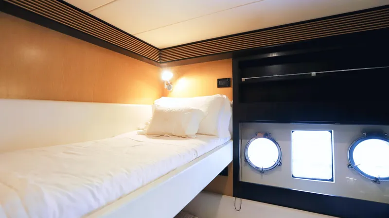W Yacht Photos Pics Interior cabin of 2009 Riva 63 Vertigo yacht with single bed and portholes.