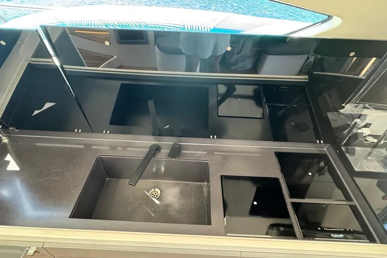  Yacht Photos Pics Modern kitchen area in a 2012 Elan 48 Power yacht, featuring sleek black countertops.