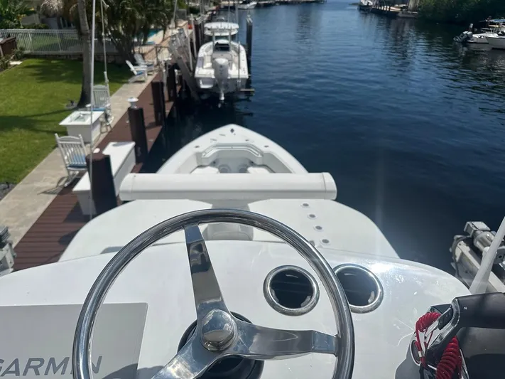  Yacht Photos Pics 2024 Contender 39 ST boat steering wheel with docked view.