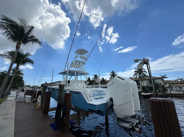 Yacht Photos Pics 2024 Contender 39 ST boat docked, featuring powerful Mercury engines, under a partly cloudy sky.