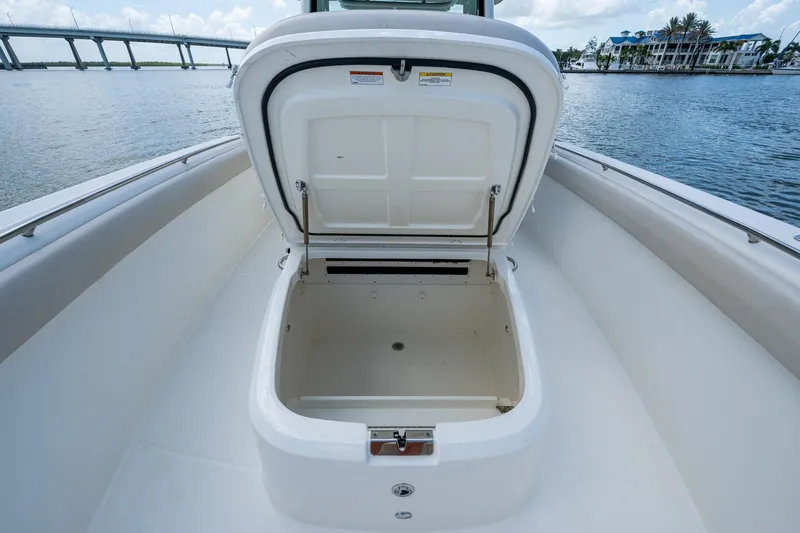 Ducky's Dinghy Yacht Photos Pics 2020 Boston Whaler 330 Outrage storage compartment open on deck, with scenic waterfront view.