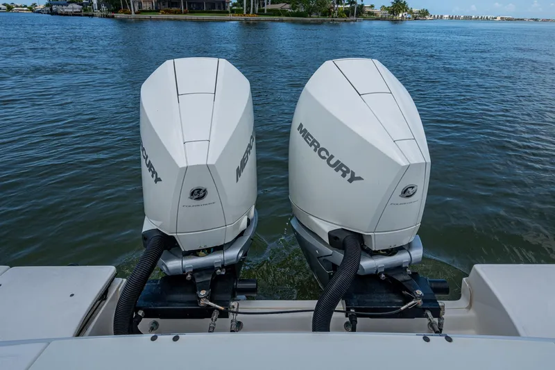 Ducky's Dinghy Yacht Photos Pics Twin Mercury outboard engines on a 2020 Boston Whaler 330 Outrage, docked on calm waters.