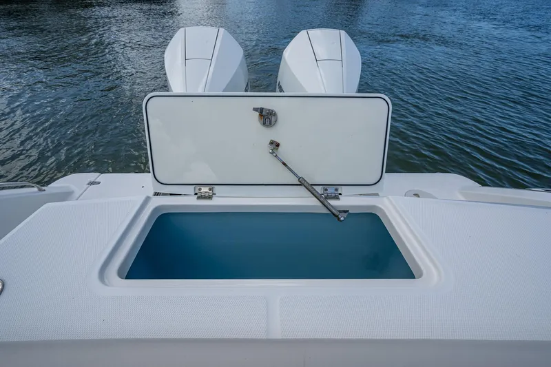 Ducky's Dinghy Yacht Photos Pics 2020 Boston Whaler 330 Outrage boat with open storage compartment, twin engines visible.
