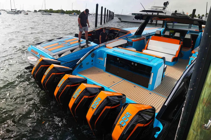  Yacht Photos Pics 2024 Cigarette 59' Tirranna boat with vibrant blue and orange design, docked in marina.