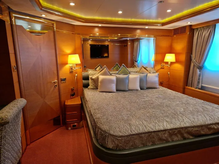  Yacht Photos Pics Luxurious bedroom interior on a 2010 Benetti Vision 145 yacht, featuring elegant decor and ambient lighting.